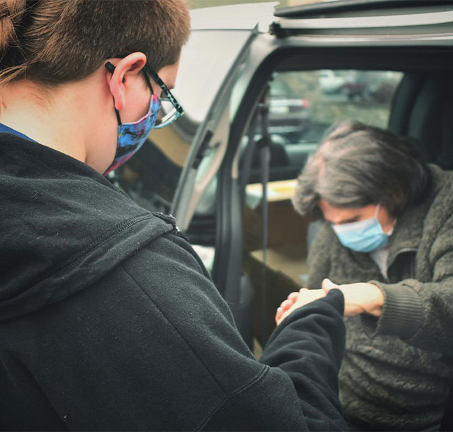 young person helping old lady getting out of the car