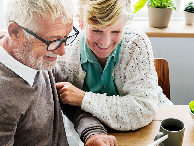 young lady reading something from the tablet while sitting with the old man